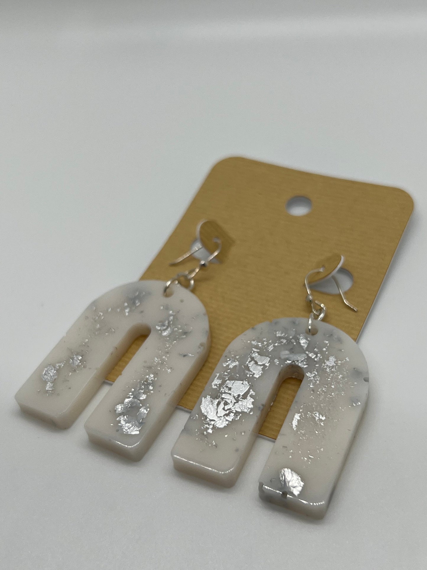 White arch earrings with silver flakes