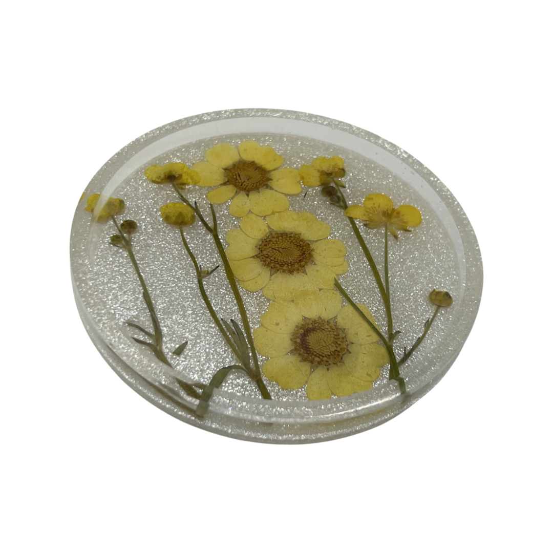 Silver circle coaster filled with sunny yellow flowers