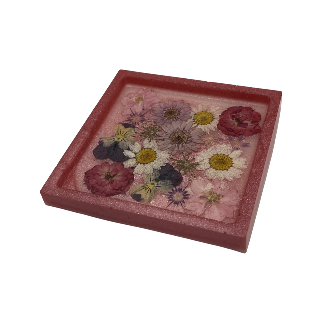 Pink square coaster filled with multicolored flowers