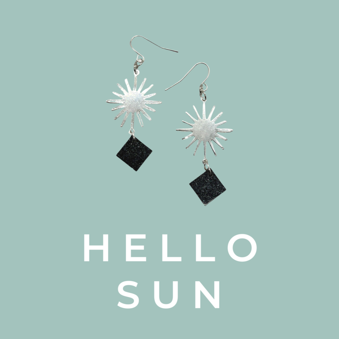 Silver sun charm with black glittery squares