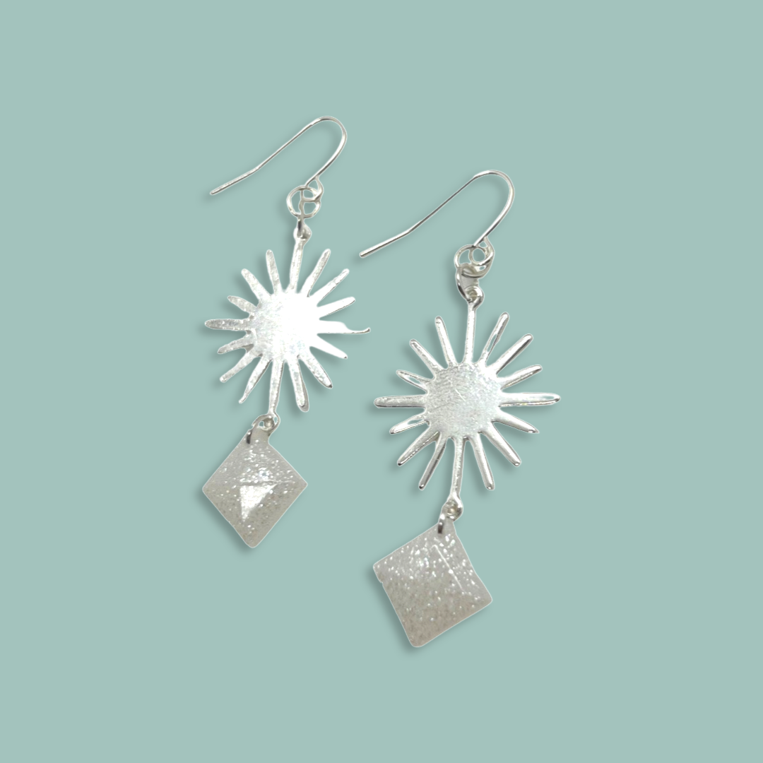 Silver sun charm with white glittery squares