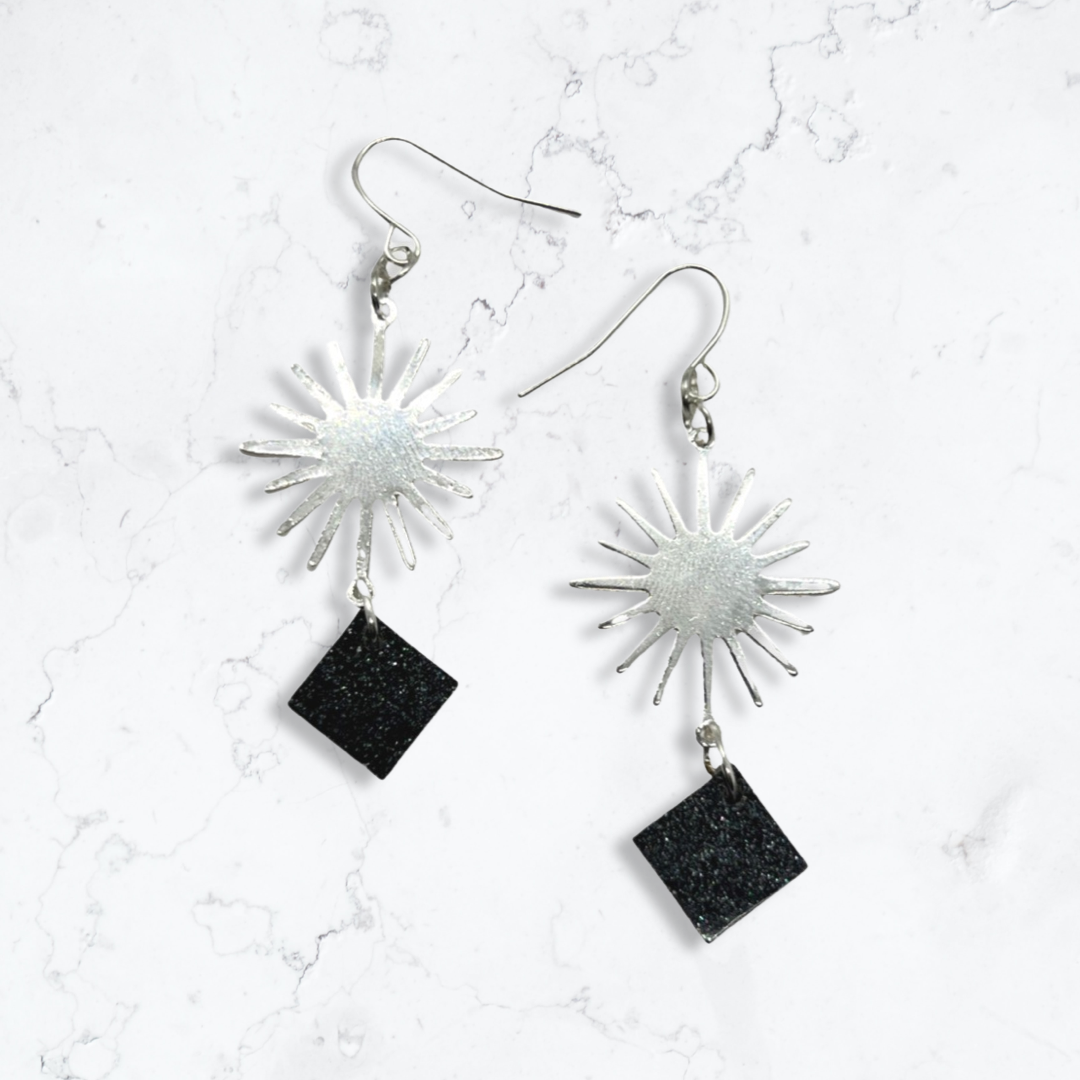 Silver sun charm with black glittery squares