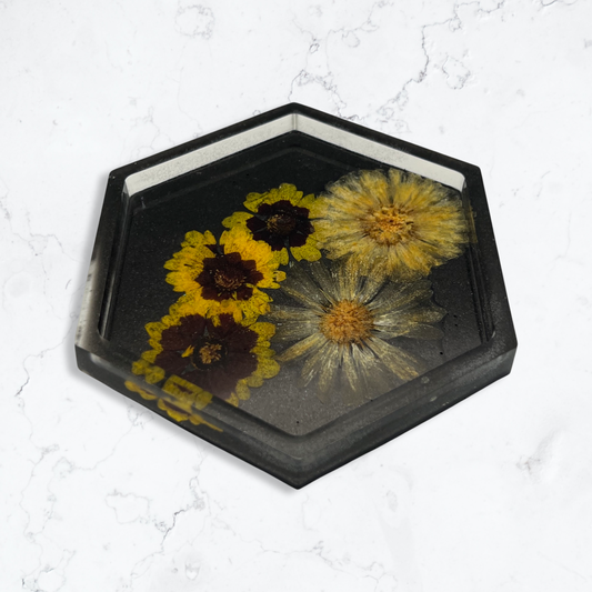 Black hexagon coaster filled with yellow flowers