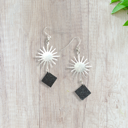 Silver sun charm with black glittery squares