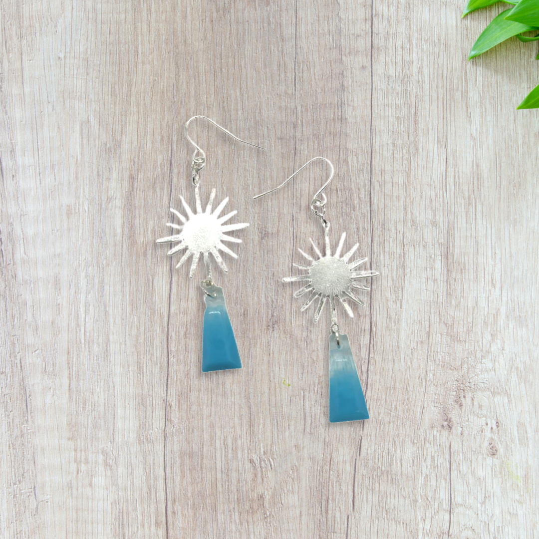 Silver sun charm with blue shapes